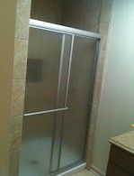 A bathroom with a sliding glass shower door and a sink.