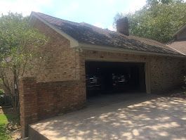 A brick house with a garage and a driveway.