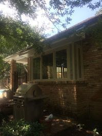 A brick house with a grill and a lot of windows.