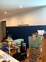 A living room filled with lots of furniture and a map of the world.