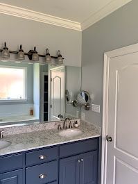 A bathroom with a sink, mirror and light fixture.