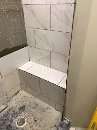 A bathroom with tiled walls and a toilet.