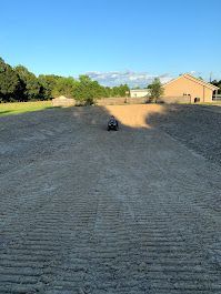 A remote control car is driving down a dirt road.