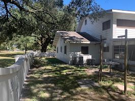 A large white house with a white fence in front of it.