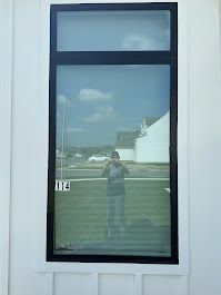 A man is taking a picture of himself in a window.