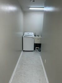 A laundry room with a washer and dryer and a sink.