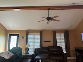 A living room with a ceiling fan and a couch.