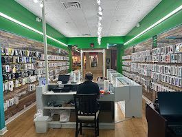A man is sitting at a desk in a cell phone store.