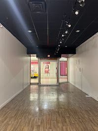 A large empty room with wooden floors and a black ceiling.