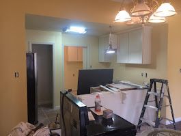 A kitchen is being remodeled and there is a ladder in the room.