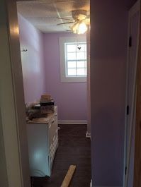 A bathroom with purple walls and a ceiling fan.