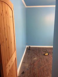 A room with blue walls and a wooden door.