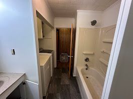 A bathroom with a bathtub , sink , and shower.