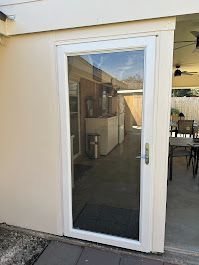 A white sliding glass door is open to a patio.