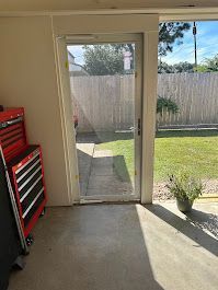 A room with a sliding glass door leading to a backyard.