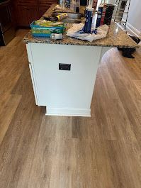 A kitchen with hardwood floors , granite counter tops , and a large island.