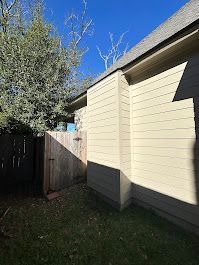 A house with a wooden fence in the backyard.