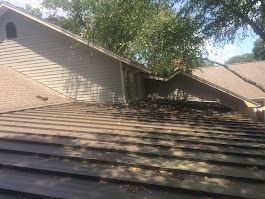 A house with a roof that has been damaged by a storm.