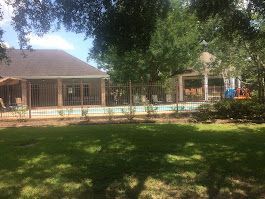 A house with a fence around it and a pool in the backyard.