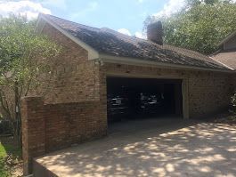 A brick house with a garage and a driveway.