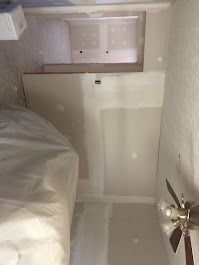 A bedroom with a ceiling fan and a bed.