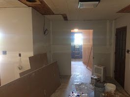 A room with a door and a ladder in it is being remodeled.