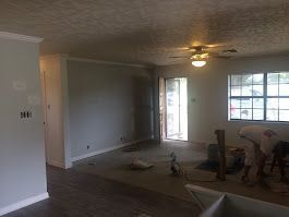 A living room with a ceiling fan and a sliding glass door.