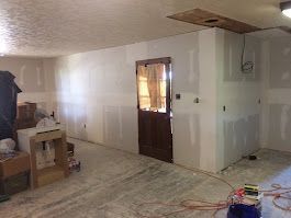 A room with white walls and a door is being remodeled.