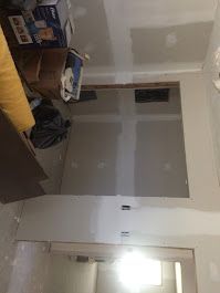 A room with a couch and a table in it is being remodeled.