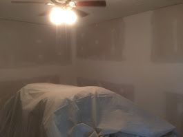 A room with a ceiling fan and a light on the ceiling.