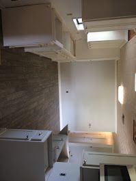 A kitchen with a stove, sink, cabinets, and a ceiling fan.