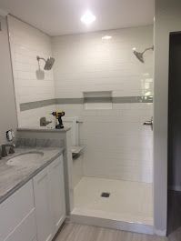 A bathroom with a walk in shower and a sink.
