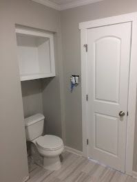 A bathroom with a toilet and a white door.