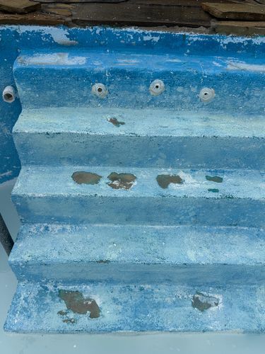 A close up of a blue and white staircase in a swimming pool.