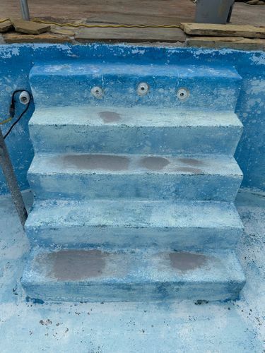 A blue and white staircase in a swimming pool.