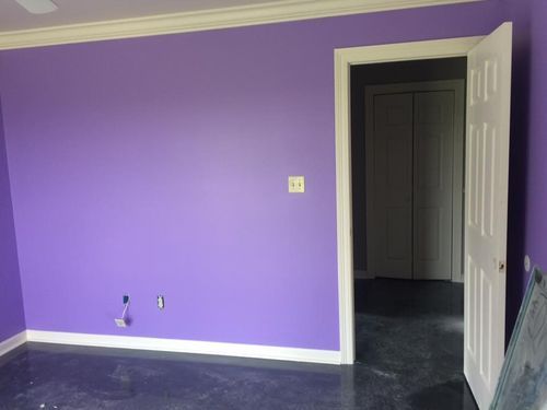 A room with purple walls and a white door