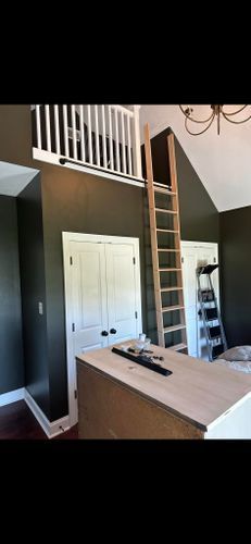 A room with a ladder leading up to a loft.