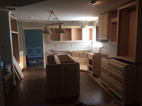 A kitchen that is being remodeled with wooden cabinets