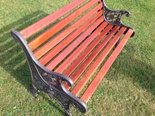 A wooden park bench is sitting on top of a lush green field.