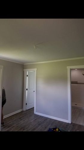 A room with a ceiling fan and a door leading to a bathroom.