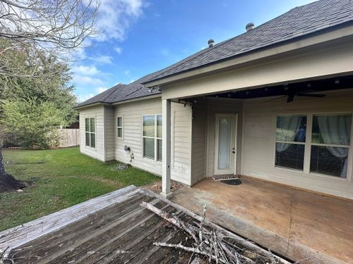 The back of a house with a porch and a lot of windows.