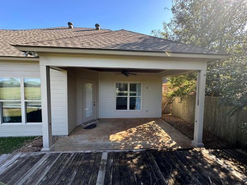 The back of a house with a covered patio and a ceiling fan.