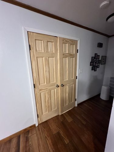 A pair of wooden doors in a room with hardwood floors.