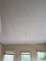 A white ceiling in a room with windows and blinds.