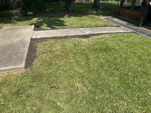 There is a concrete walkway in the middle of the grass.