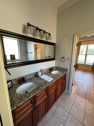 A bathroom with two sinks and a large mirror.
