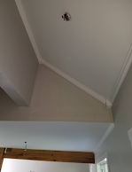 The ceiling of a room with a vaulted ceiling and a wooden beam.