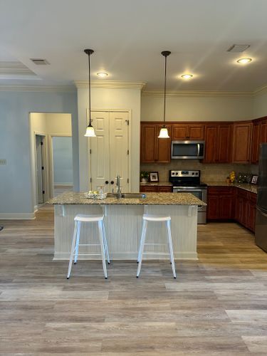 A kitchen with a large island and two stools.