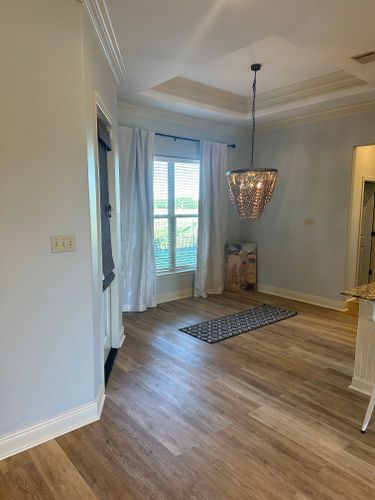A living room with hardwood floors and a chandelier hanging from the ceiling.
