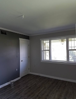 An empty room with a lot of windows and a wooden floor.